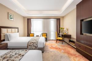 上海市にあるShangHai LuAn Garden Hotelのベッド2台と薄型テレビ付きのホテルの部屋