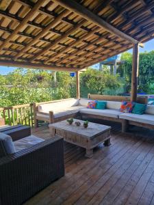 a patio with couches and a table on a wooden deck at Casa da Briana in Trancoso +21 photos