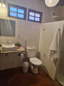 a bathroom with a toilet and a sink and a mirror at Casa da Briana in Trancoso