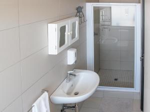 a white bathroom with a sink and a shower at Rieks van der Walt Self-Catering Apartment in Windhoek +53 photos