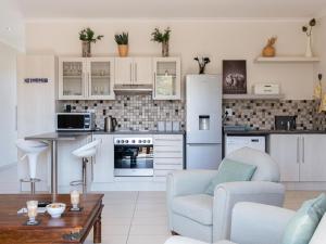 a kitchen with a couch and a chair and a table at Rieks van der Walt Self-Catering Apartment in Windhoek