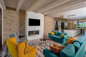 a living room with blue couches and yellow chairs at Relais Tenuta Santori in Cossignano