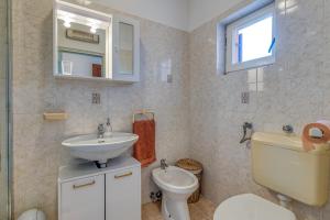 a bathroom with a sink and a toilet and a window at Apartment Nino in Kanfanar +18 photos