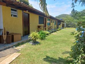 a row of cottages with a grass yard at Pousada da Praia II in Guarujá