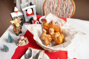 una mesa con una cesta de pan en una mesa con adornos navideños en Bed & Breakfast Tiffany, en Domodossola