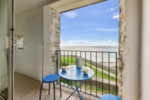 a table and chairs on a balcony with a view of the ocean at Face à l'océan - Arzon - Appartement pour 4 in Arzon +7 photos