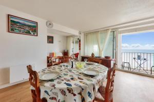 a dining room with a table and a view of the ocean at Face à l'océan - Arzon - Appartement pour 4 in Arzon