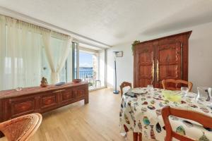 a dining room with a table and a large window at Face à l'océan - Arzon - Appartement pour 4 in Arzon