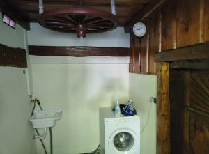 un bagno con lavatrice e orologio di Juliana House a Križanče Altre 15 foto