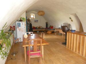a living room with a table and a refrigerator at Ferme de la Rose in Rosans