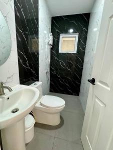 a bathroom with a white toilet and a sink at Casa Leonardo-Bel Air 4 in Santa Rosa +17 photos