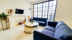 a living room with two blue couches and a tv at La'Rissa Residence by ARBA in Karawang