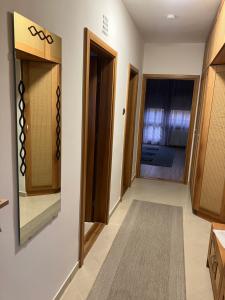 a hallway with wooden cabinets and a door at JAMA-KECÓ Apartman in Bonyhád