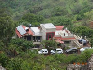 a house with cars parked in front of it at Malhar Bungalow in Panchgani