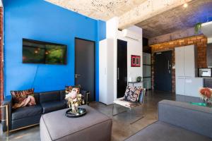 un salon avec un canapé et un mur bleu dans l'établissement Manhattan-style 2-bedroom apartment, au Cap