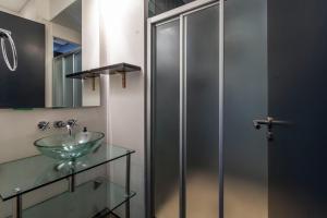 La salle de bains est pourvue d'un lavabo en verre et d'une douche. dans l'établissement Manhattan-style 2-bedroom apartment, au Cap 27 autres photos