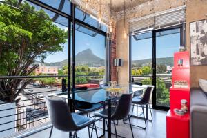 une salle à manger avec une table et des chaises et une grande fenêtre dans l'établissement Manhattan-style 2-bedroom apartment, au Cap
