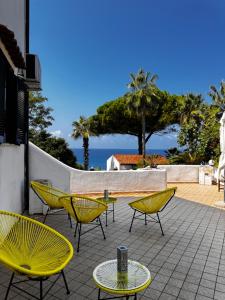a group of yellow chairs and tables on a patio at Boutique San Daniele B&B in Cirella