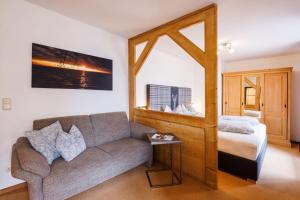 a living room with a couch and a bed at Gästehaus Wolfgang Chiemsee -1- in Ruhpolding