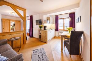 a living room with a table and a kitchen at Gästehaus Wolfgang Chiemsee -1- in Ruhpolding