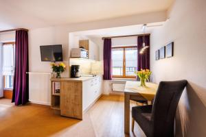 a kitchen with a desk and a table with a chair at Gästehaus Wolfgang Chiemsee -1- in Ruhpolding