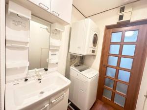 une salle de bain avec un lavabo et une machine à laver dans l'établissement 新規割引表参道原宿高級住宅地の贅沢隠れ家一軒家貸切駅ショッピング徒歩2分3路線浅草銀座直通, à Tokyo