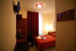 a hotel room with a red bed and a window at Hotel Della Volta in Brescia