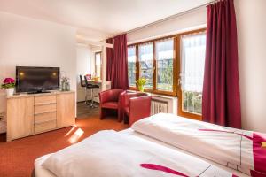 una habitación de hotel con una cama y un televisor en Gästehaus Wolfgang Mittersee -4-, en Ruhpolding