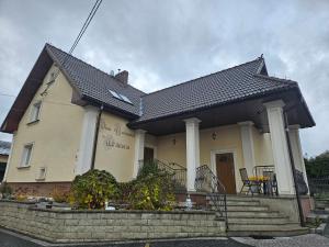 a yellow house with a black roof at Dom Noclegowy Wiktoria in Skrzyszów