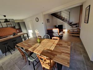 a kitchen and living room with a wooden table and chairs at Gîte de la Tuilerie in Rougemont