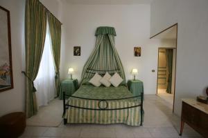 a bedroom with a green bed with a canopy at Villa Grant Relais in La Capocotta +10 photos