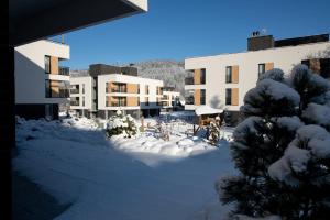 un patio cubierto de nieve frente a un edificio en VISLOW Resort, en Wisła