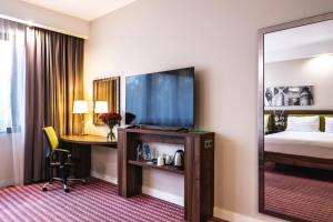 a hotel room with a bed and a desk and a television at Hampton by Hilton Świnoujscie in Świnoujście