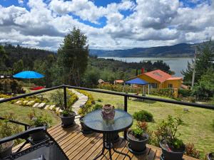 a deck with a table and a view of a lake at Danys Lodges in Guatavita +19 photos