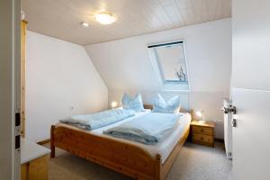 una camera da letto con un letto con lenzuola blu e una finestra di Bauernhof Angelika Schulze Pellworm a Pellworm