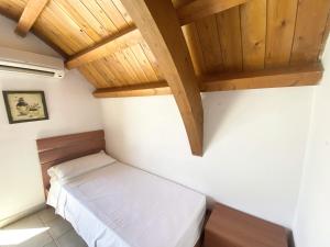 a bedroom with a bed and a wooden ceiling at Isca Calabretta Apartments M28 in Isca sullo Ionio +33 photos