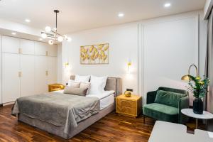 een slaapkamer met een bed en een groene stoel bij HOTEL METROPOL Club House in Jerevan