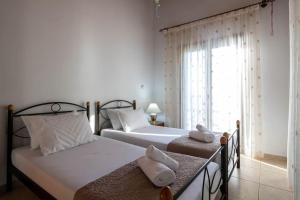 two twin beds in a room with a window at Villa Nerea in Kitriaí
