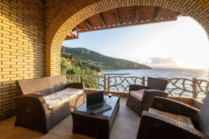 a patio with chairs and a table with a laptop on it at Villa Nerea in Kitriaí