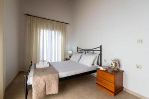 a bedroom with a large bed and a wooden dresser at Villa Nerea in Kitriaí