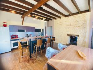 a kitchen with a table and chairs and a stove at Location maison Mirambeau - 17150 in Mirambeau