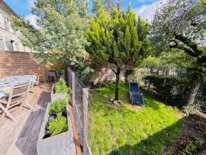 a backyard with a fence and a bench and trees at Location maison Mirambeau - 17150 in Mirambeau