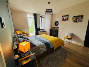 a bedroom with a bed with a yellow and blue blanket at Location maison Mirambeau - 17150 in Mirambeau