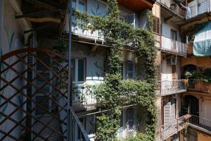 ein Wohnhaus, in dem Pflanzen auf den Balkonen wachsen in der Unterkunft Tomato Urban Retreat in Turin
