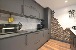 eine Küche mit grauen Schränken und einer Arbeitsplatte in der Unterkunft Bennett's Cottage in Kings Lynn + 16 Fotos