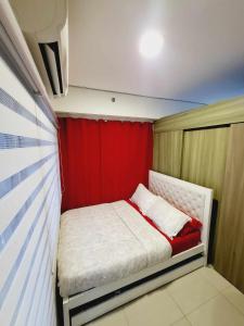 a small bed in a room with a red curtain at Mavic Staycation in Manila