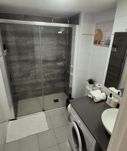 a bathroom with a shower and a washing machine at Beach House in San Bartolomé de Tirajana