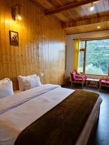 a bedroom with a large bed in a wooden wall at Crystal Mountain Homestay - Jibhi Market in Jibhi