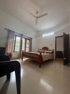 a bedroom with a bed and a ceiling fan at Nature's View Service Villa in Vythiri +14 photos