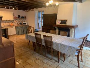 una cucina con tavolo e sedie e una cucina con camino di Maison Lushbrooks a Moutier-Malcard
